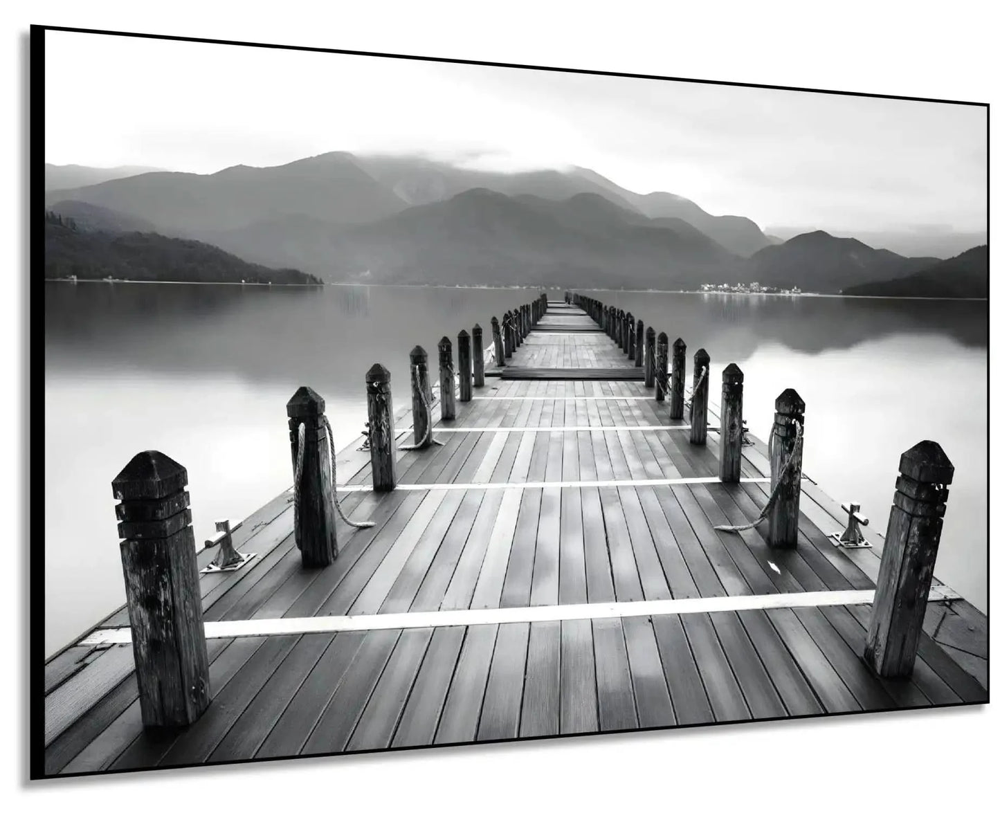 Pont en bois noir et blanc s'étendant vers l'horizon, entouré de montagnes, créant une ambiance sereine et contemplative.