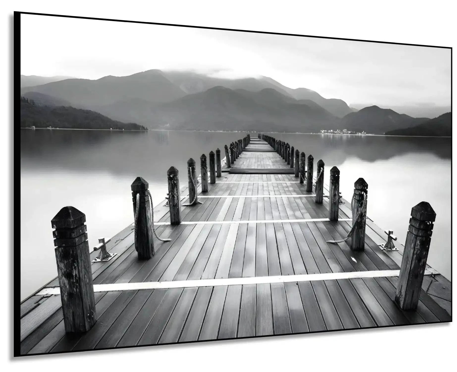 Pont en bois noir et blanc s'étendant vers l'horizon, entouré de montagnes, créant une ambiance sereine et contemplative.