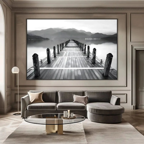 Pont en bois noir et blanc s'étendant vers l'horizon, entouré de montagnes, créant une ambiance sereine et contemplative.