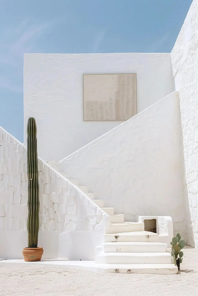 Photographie minimaliste d’un escalier blanc et d’un cactus, sous un ciel bleu apaisant, idéale pour une décoration de chambre. 