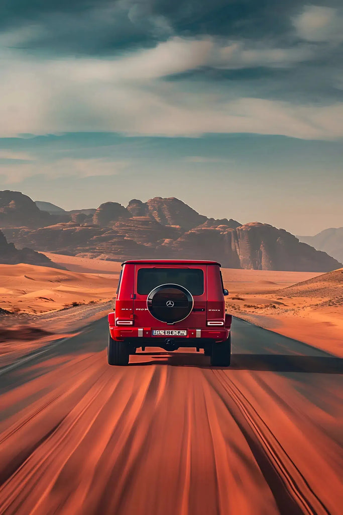 Photographie d’un 4x4 rouge roulant dans un désert aux tons chauds, capturant l’esprit d’aventure et de liberté. 