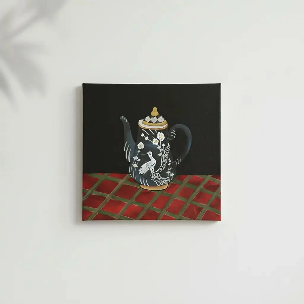 Tableau d'une théière noire avec motifs d'oiseau blanc et fleurs, sur fond noir et table rouge, ambiance élégante et mystérie