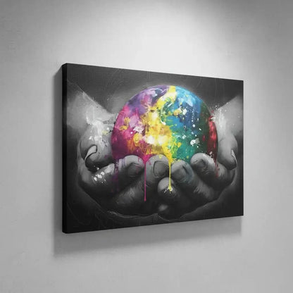 Sphère multicolore avec éclats de jaune, bleu et rose, tenue par des mains en noir et blanc, contraste vibrant et dynamique.