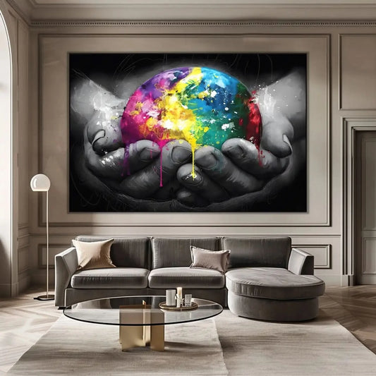 Sphère multicolore avec éclats de jaune, bleu et rose, tenue par des mains en noir et blanc, contraste vibrant et dynamique.