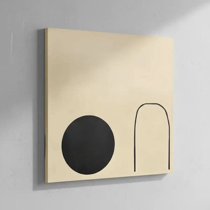 Forme abstraite noire suspendue par une ligne fine sur un fond crème, offrant une impression de mouvement dans un espace minimaliste.