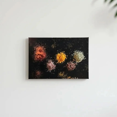 Explosion d’épices abstraite: paprika rouge, curcuma jaune, sel rose et graines blanches sur fond noir; oeuvre mystérieuse.