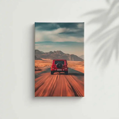 Photographie d'un voiture rouge roulant sur une route désertique, avec un paysage de montagnes lointaines, créant une ambiance d'aventure.