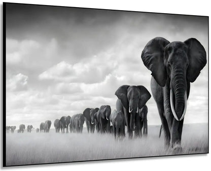 Tableau noir et blanc d'une file d'éléphants avançant dans la savane sous un ciel nuageux, symbole de force et d'unité.