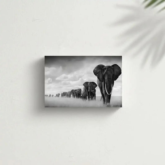 Tableau noir et blanc d'une file d'éléphants avançant dans la savane sous un ciel nuageux, symbole de force et d'unité.