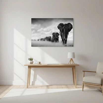 Tableau noir et blanc d'une file d'éléphants avançant dans la savane sous un ciel nuageux, symbole de force et d'unité.
