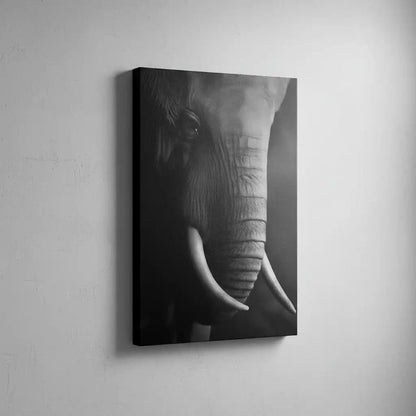 Gros plan en noir et blanc sur le visage d'un éléphant mettant en valeur la texture de sa peau et la courbe de sa défense.
