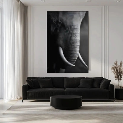 Gros plan en noir et blanc sur le visage d'un éléphant mettant en valeur la texture de sa peau et la courbe de sa défense.