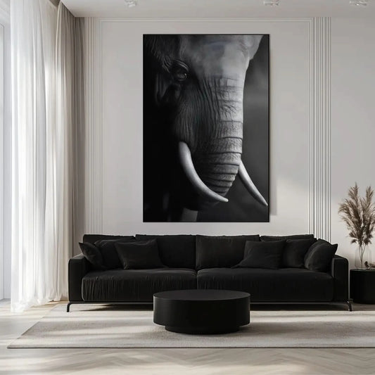 Gros plan en noir et blanc sur le visage d'un éléphant mettant en valeur la texture de sa peau et la courbe de sa défense.