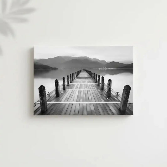 Pont en bois noir et blanc s'étendant vers l'horizon, entouré de montagnes, créant une ambiance sereine et contemplative.