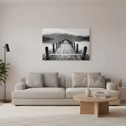 Pont en bois noir et blanc s'étendant vers l'horizon, entouré de montagnes, créant une ambiance sereine et contemplative.