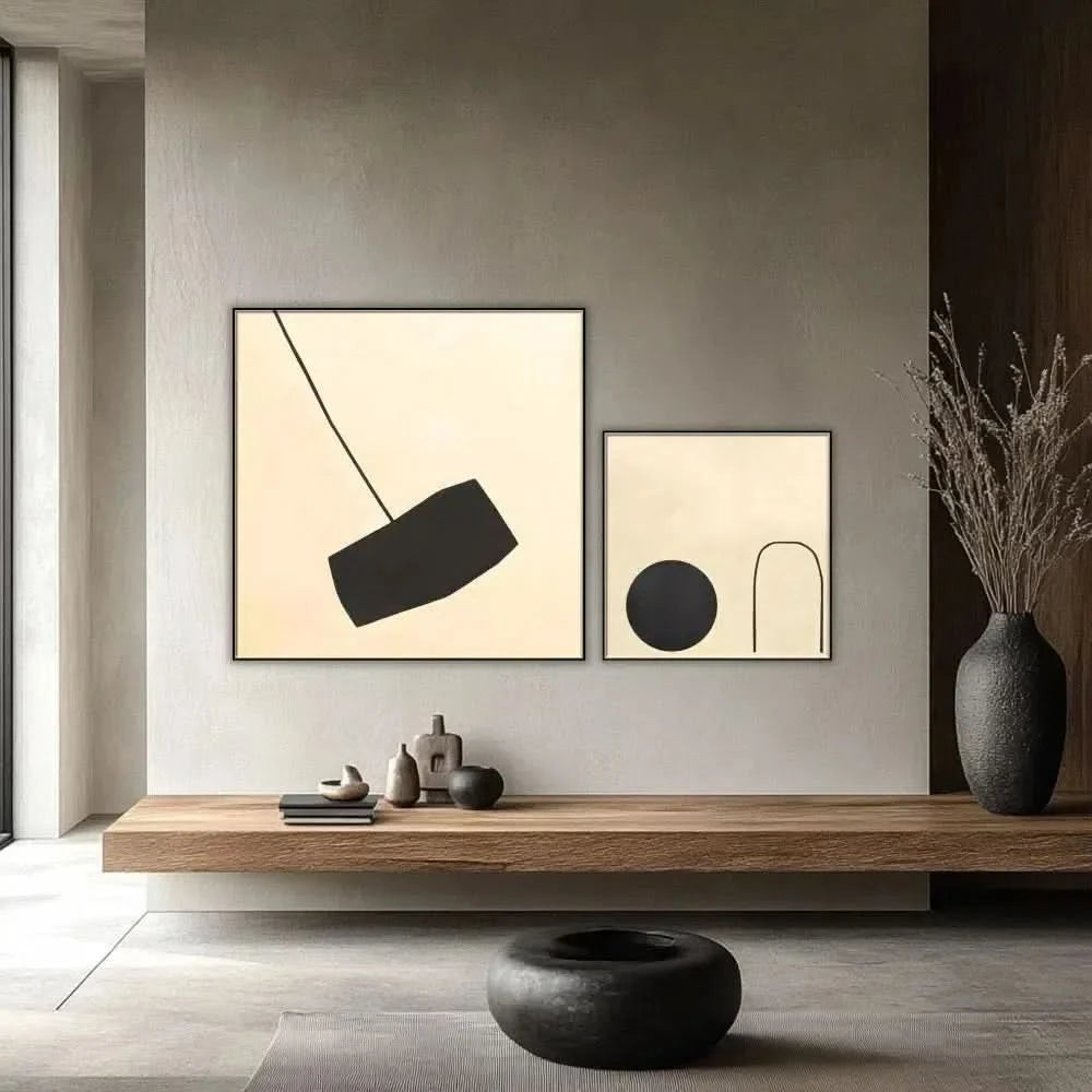 Tableau minimaliste avec fond beige et forme noire suspendue. Contraste subtil, idéal pour un salon moderne.